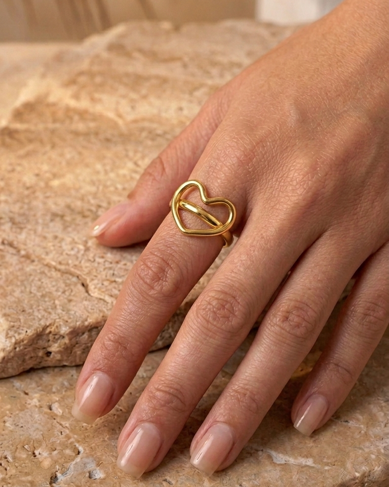 Bague cœur dorée portée à la main