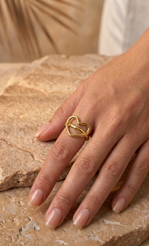 Bague cœur dorée portée à la main